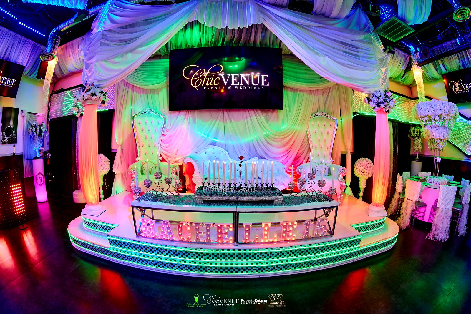Furnished Chic Venue stage with a large TV screen and colorful green lighting